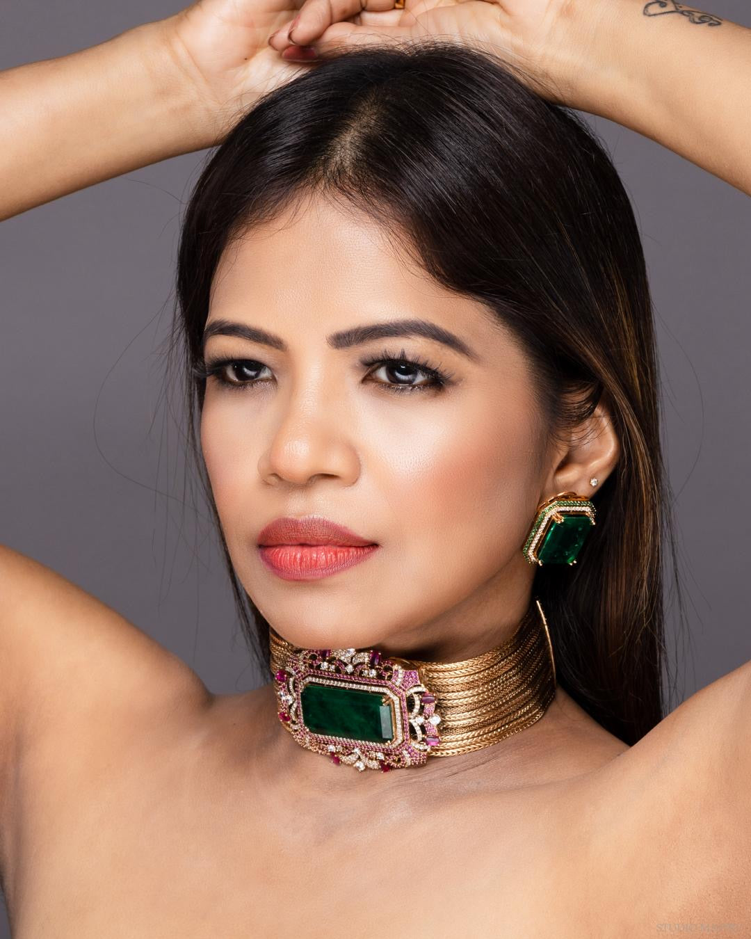 Luxurious emerald choker necklace set accented with sparkling stones, frontal view